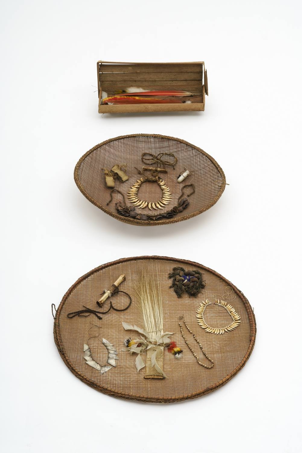 Installation nach Feliciano Lana: Siebe mit dem Schmuck zur Erschaffung der Menschheit und ein Kästchen für Federschmuck. Von Indigenen Gemeinschaften im Gebiet des Oberen Rio Negro, Brasilien/Kolumbien. Sammler: Hermann Schmidt (vor 1914), Lothar Petersen (vor 1959) und Hans Wegmann (1967-2002). Diverse Materialien. Foto: Wolfgang Günzel