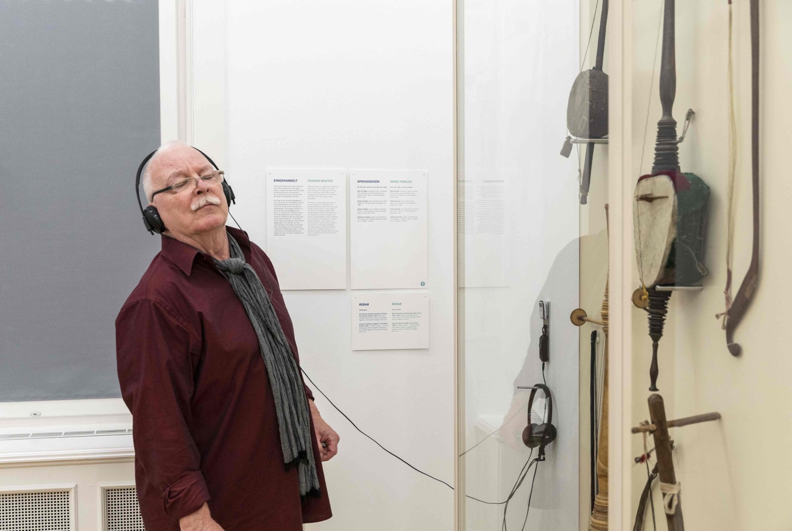 Besucher in der Ausstellung WELTENBEWEGEND vor Musikinstrumenten