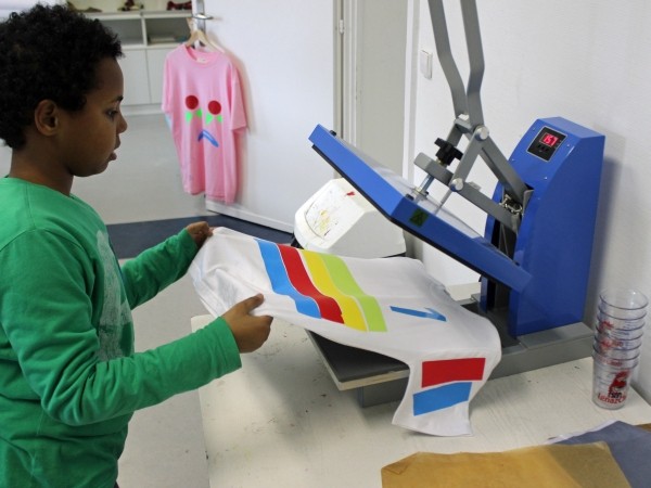 Kinder bedrucken T-Shirts im Workshop. Foto: Weltkulturen Museum