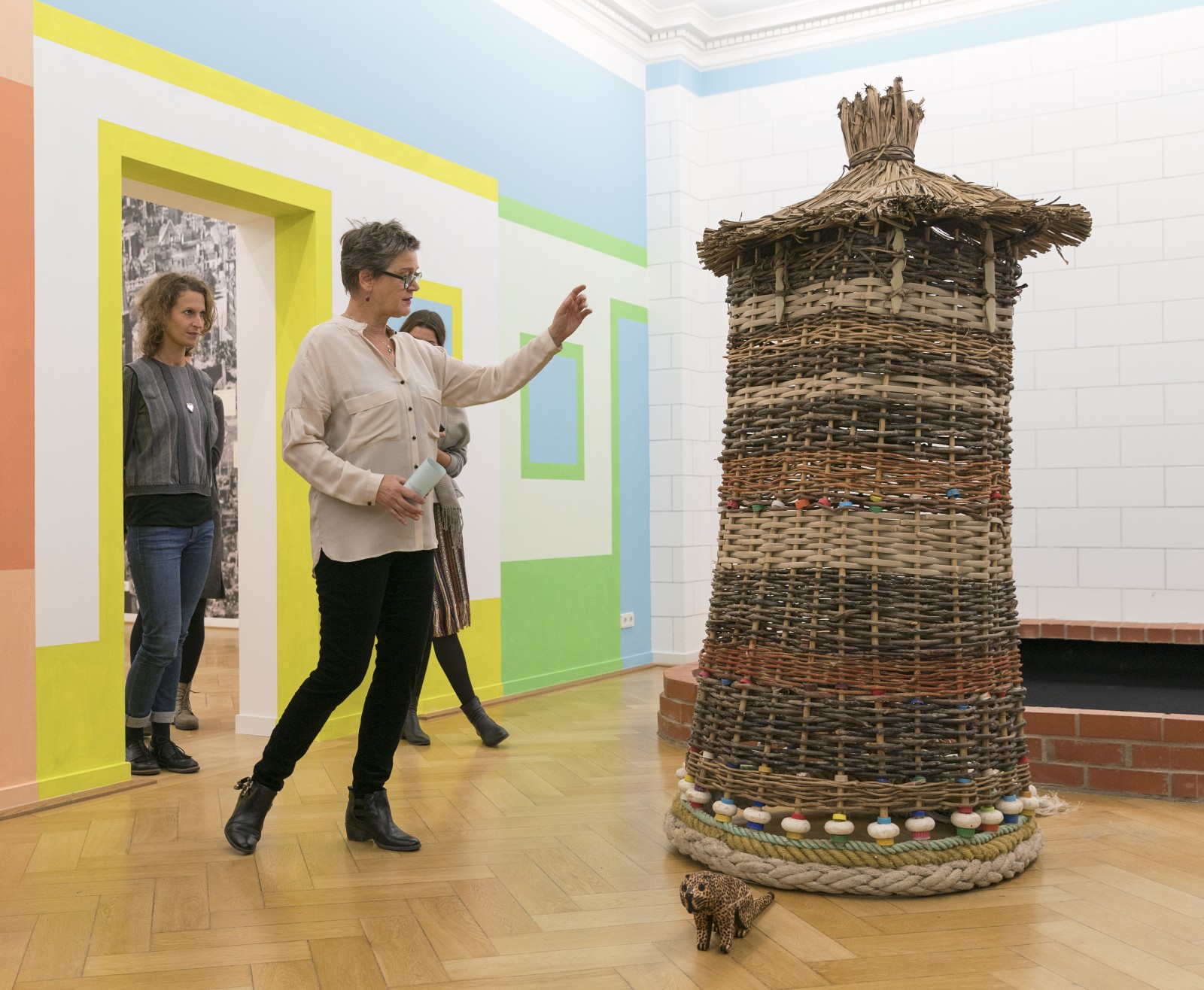 Curator Mona Suhrbier presents a sculpture by Guaraní (part of an installation by Rigo 23), exhibition ”Entre Terra e Mar”, Weltkulturen Museum 2017