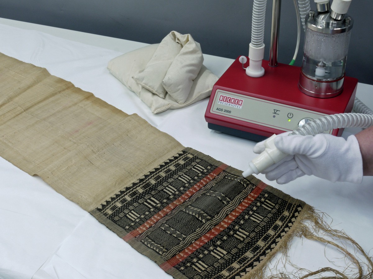 Smoothing of cloth with a ultrasonic nebuliser. Photo: Weltkulturen Museum