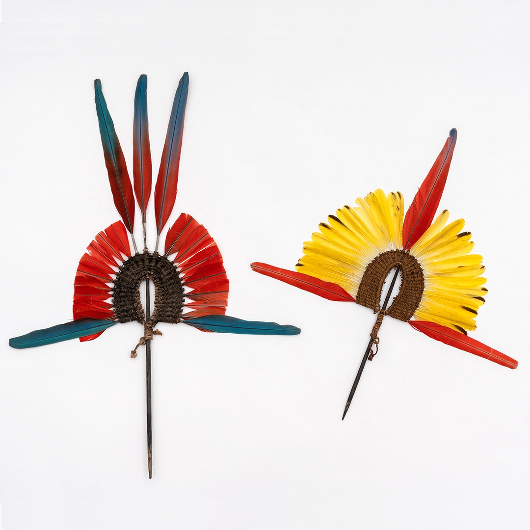 The headdress Àkkàpa’ri is stuck into a ‘hat’ made from painted beeswax which is glued into the hair. This headdress is made and worn exclusively by men. The colour of the feathers used is dependent on personal privileges. Feathers, cotton and wood.  Kayapó Mekrãgnoti, Pará, Brazil. Collected by Gustaaf Verswijver, 1992. Collection Weltkulturen Museum. Photo: Wolfgang Günzel
